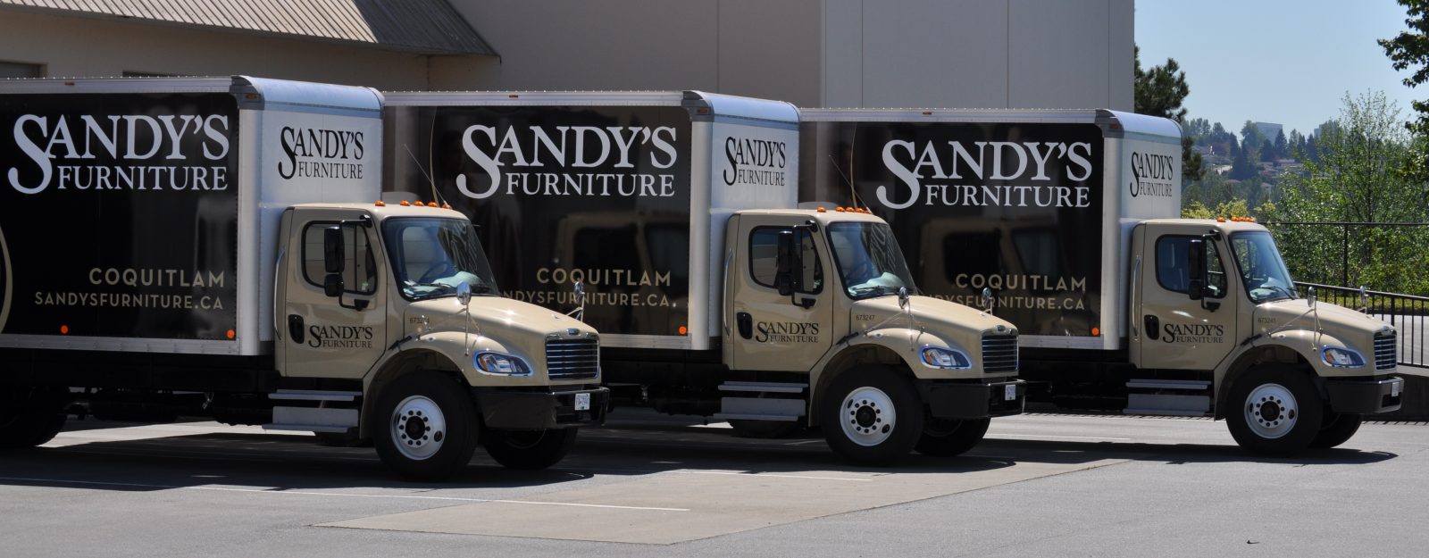 Sandy's Furniture delivery trucks lined up at the furniture store